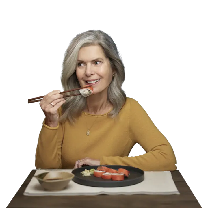 middle aged woman enjoying sushi takeout at home